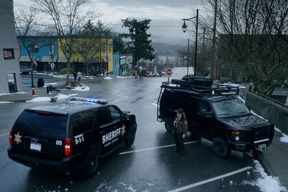 Agent Liv Baker (Elizabeth Bowen) stands between a police car and black truck on Resident Alien Episode 216.